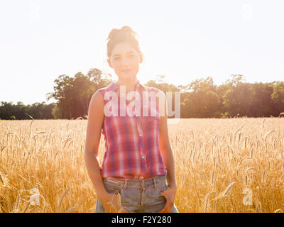 A young woman standing in a field of tall ripe corn. Stock Photo