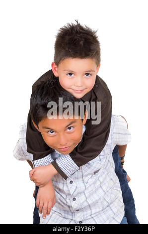 Two small hispanic boys playing, one carrying the other on his back, facing camera Stock Photo