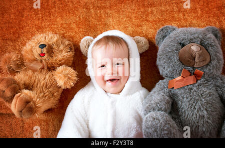 Little baby in bear costume with plush toys Stock Photo