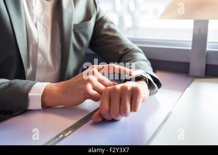 In the train a man using his smartwatch. Close-up hands Stock Photo