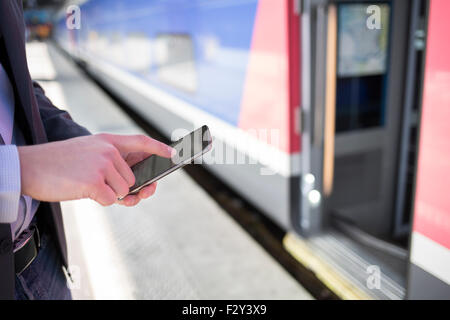 On platform station a man using his cell phone. Close-up hands Stock Photo