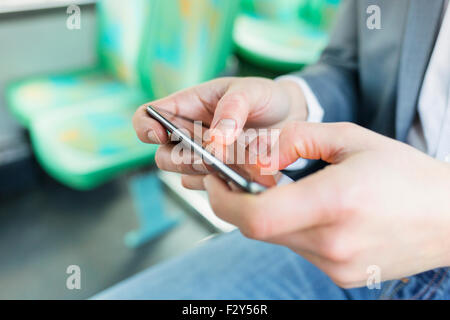 On bus man texting sms, using cell phone apps. gaming. Close-up hands Stock Photo