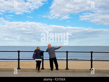 Man and woman, pointing out to sea, Cleethorpes, Lincolnshire, England UK Stock Photo