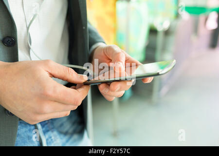 Man using his cell phone. listen music . At bus. texting  message. Close-up hands Stock Photo
