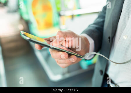 Man listening music with mobile phone. on bus. texting  message. Close-up hands Stock Photo