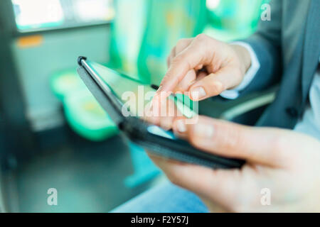 On bus man using digital tablet. Reading emails. texting  message. Close-up hands Stock Photo