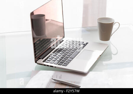 Laptop on modern glass table in office Stock Photo