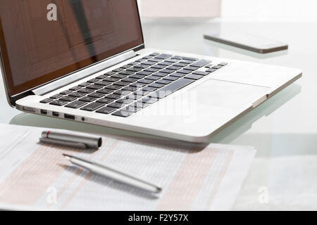 Laptop on modern glass table in office Stock Photo