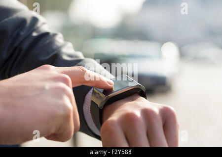 Outdoors man using his smart watch. Close-up hands Stock Photo