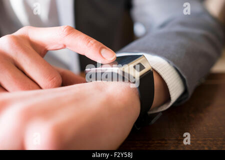 In coffee bar a man using his smartwatch. Close-up hands Stock Photo
