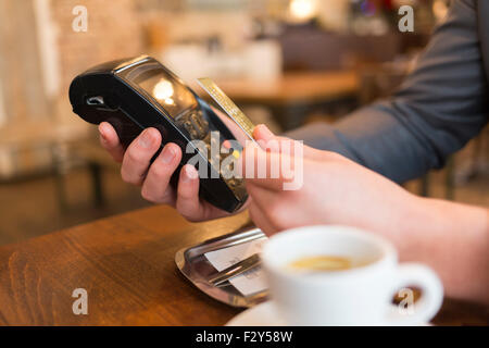 Man paying with NFC technology , credit card, in restaurant, bar, cafe Stock Photo