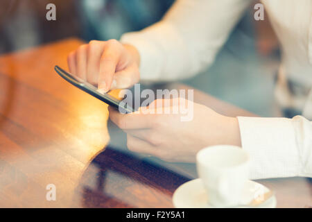 Man in a bar using mobile phone. Vintage filter Stock Photo