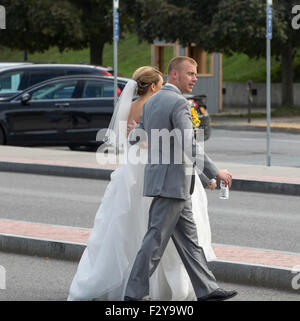 Bride in gown and Groom in tux walking in Lake George New York USA Adirondack State Park on their wedding day. Stock Photo