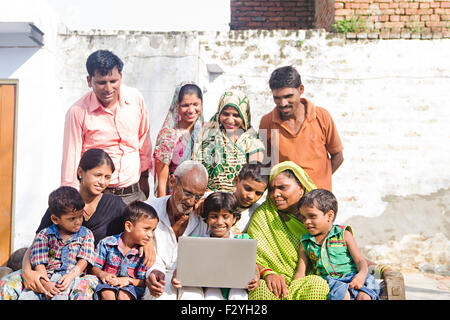 indian group crowds rural villager Joint Family home sitting laptop working Stock Photo