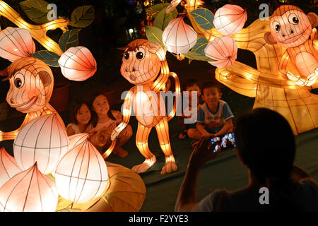 Singapore. 26th Sep, 2015. Children pose for photos with the lantern decorations on the eve of the Mid-Autumn Festival celebrations held in Singapore's Lian Shan Shuang Lin Monastery on Sept. 26, 2015. © Then Chih Wey/Xinhua/Alamy Live News Stock Photo