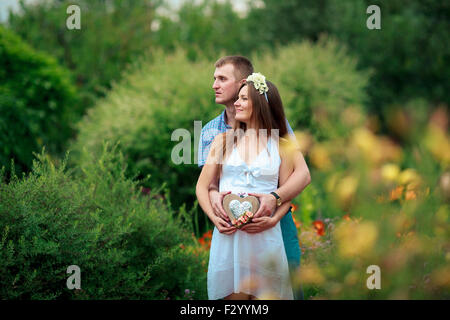 Happy and young pregnant couple in nature Stock Photo