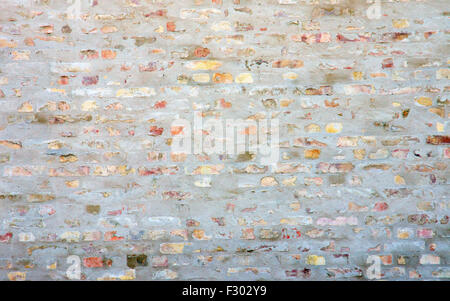 A rough brickwall with the remains of white plaster Stock Photo