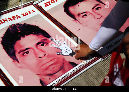 La Paz, Bolivia, 26th September 2015. A protester places a paper hand with 'Nos falta 43' ('43 are missing') written on it on a photo of one of the missing students outside the Mexican Embassy in La Paz. The students disappeared one year ago today on the night of 26th September 2014 in the town of Iguala in Guerrero State. The Mexican government's handling of the case has been widely criticised and a team sent by the Inter-American Commission on Human Rights found a number of flaws in the government's investigation. Stock Photo