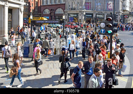 London street Oxford Circus tube station entrance & people at roadside waiting at pedestrian crossing junction of Regent Street & Oxford Street UK Stock Photo