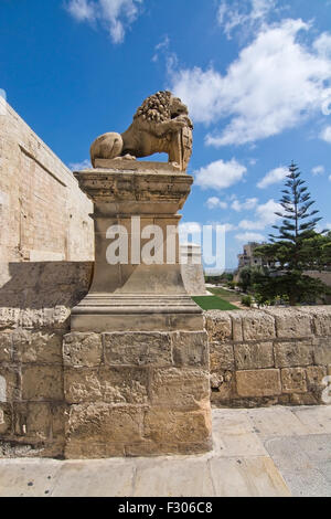 Guardian lion in profile by the entrance to the old city walls on a sunny day in Mdina, Malta. Stock Photo