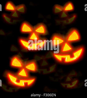 Lots of pumpkins lit brightly against a black background Stock Photo