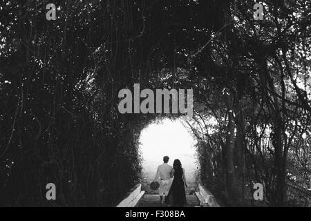 couple walking through the tunnel of trees Stock Photo