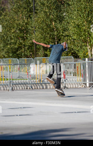 A Young lad performing tricks on his skateboard in a car park in Birmingham West Midlands UK Stock Photo