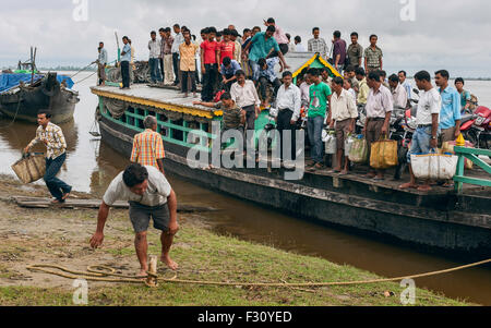 Passengers disembark from ferry at Nimati Ghat having crossed the Brahmaputra river from Majuli. Stock Photo