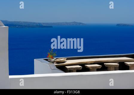 A wooden bench and chairs with a caldera view in the village of Oia,Santorini,Greece Stock Photo