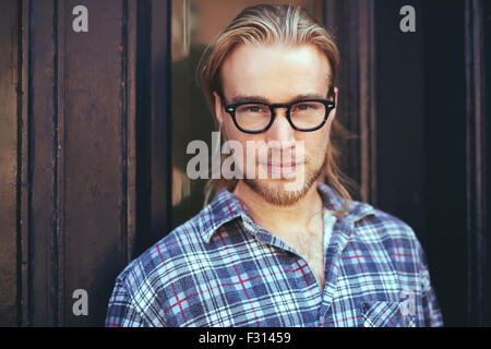 closeup portrait of blond man with long hair and glasses. Thoughtful man Stock Photo