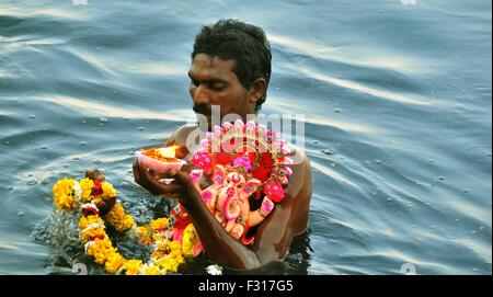 New Delhi, India. 27th Sep, 2015. Indian devotee carries an idol of elephant-headed Hindu God Lord Ganesha for immersion in the Yamuna river in New Delhi. During the eleventh-day of Ganesh Festival Hindu devotees bring home idols of Lord Ganesha and offer prayers in temporary temples in order to invoke blessings for wisdom and prosperity, culminating with the immersion of the idols in bodies of water, including the ocean on the last day Credit:  Hemant Rawat/Pacific Press/Alamy Live News Stock Photo