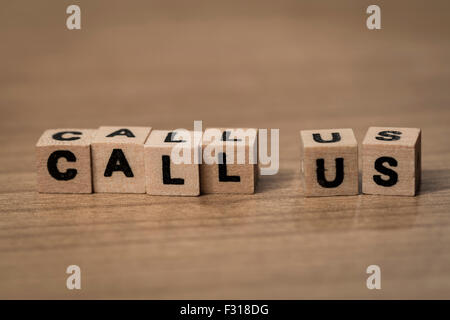 Call us written in wooden cubes on a desk Stock Photo