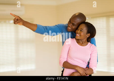 cheerful young African couple looking round their new house Stock Photo