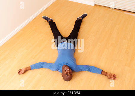 overhead view of young African man lying on the floor in his new home Stock Photo