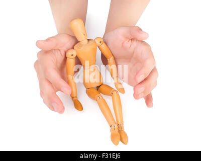 female hands covering wooden man isolated on white with clipping path Stock Photo