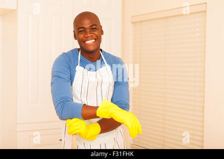 portrait of cheerful African man cleaning his bedroom Stock Photo