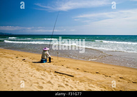 fish man fishing on the beach under sunbath Stock Photo