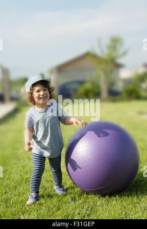 Little toddler boy having fun outside with big ball Stock Photo