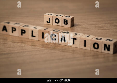 Job Application written in wooden cubes on a desk Stock Photo