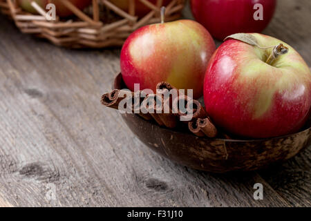 cinnamon sticks and apples on the old wooden background Stock Photo