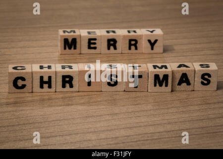 Merry Christmas written in wooden cubes on a desk Stock Photo