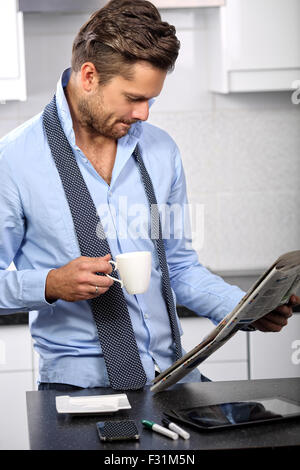 Young and handsome businessman reading a morning newspaper Stock Photo