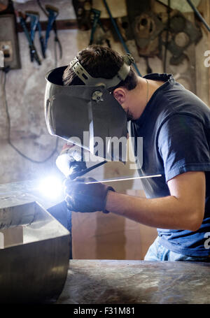 Welder or metalworker doing welding in an industrial metal workshop Stock Photo