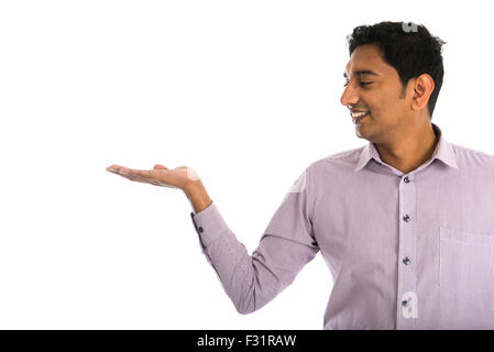 portrait of young businessman pointing at invisible product over white background. Stock Photo