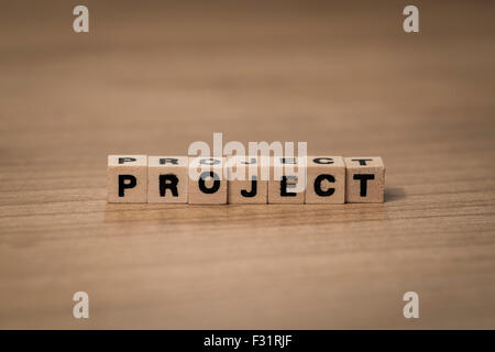 Project written in wooden cubes on a desk Stock Photo