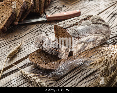 Sliced black bread on the old wooden plank.