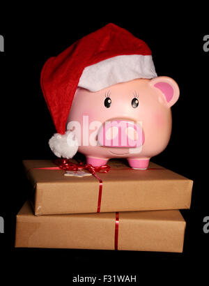 Santa piggy bank and christmas presents on black background Stock Photo