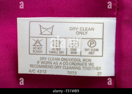 label in pink dress garment - dry clean only cool iron, if worn as a co-ordinate we recommend dry cleaning together - care washing symbols Stock Photo