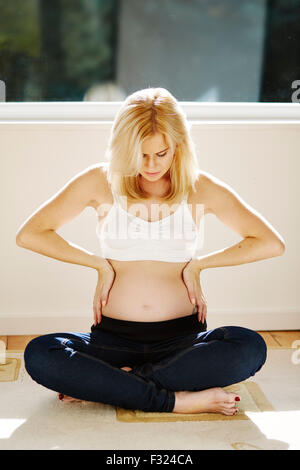 Pregnant woman feeling baby kick Stock Photo