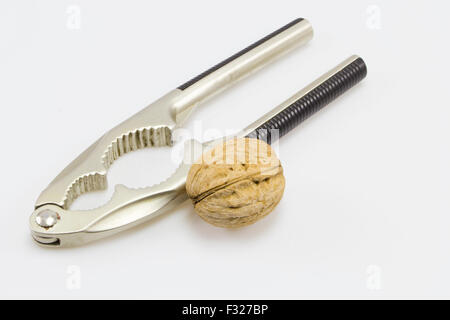 Nutcracker and a walnut isolated on a white background Stock Photo